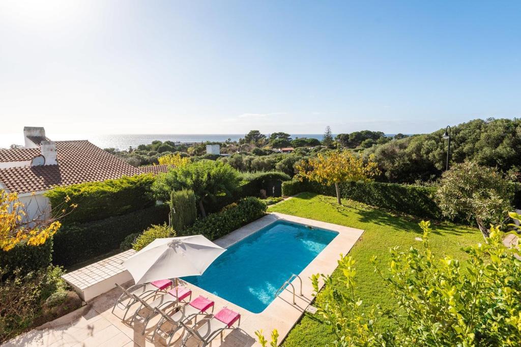 a villa with a swimming pool and a garden at Estrella Del Mar with Private Pool in Binibeca