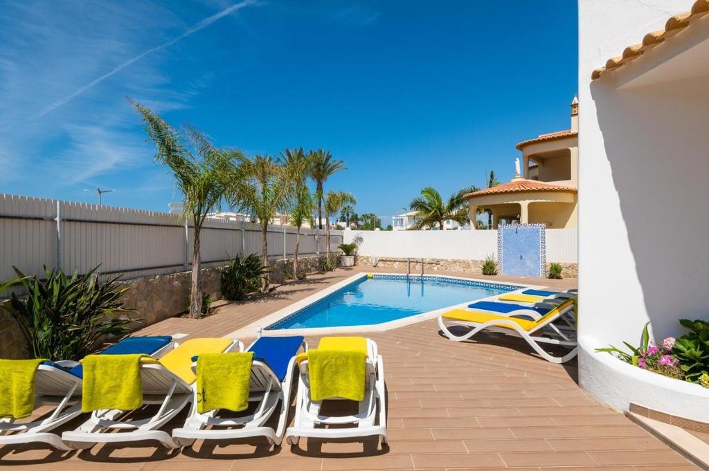 a patio with lounge chairs and a swimming pool at Villa Miramar Gale by Villa Select in Galé