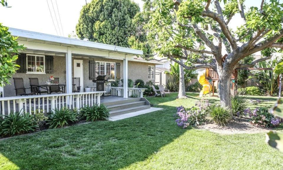 a house with a porch and a yard at Charming Anaheim Home 1/2 Mile Walk to Disney in Anaheim
