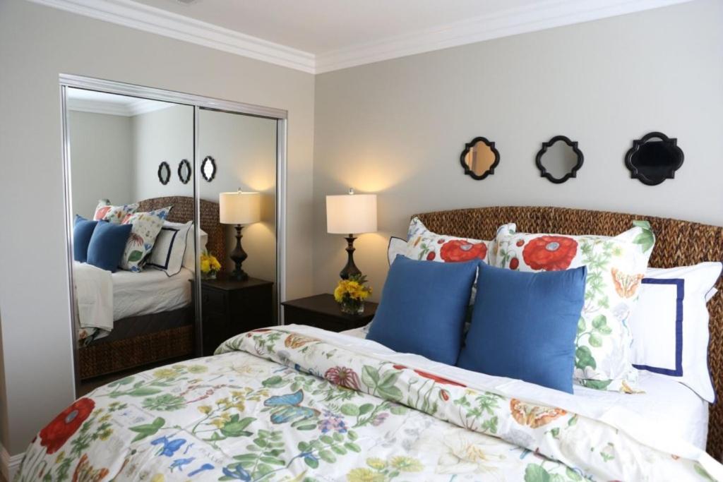 a bedroom with a bed with blue pillows and a mirror at Adorable 3 Bedroom 2 Bath Home in Fullerton