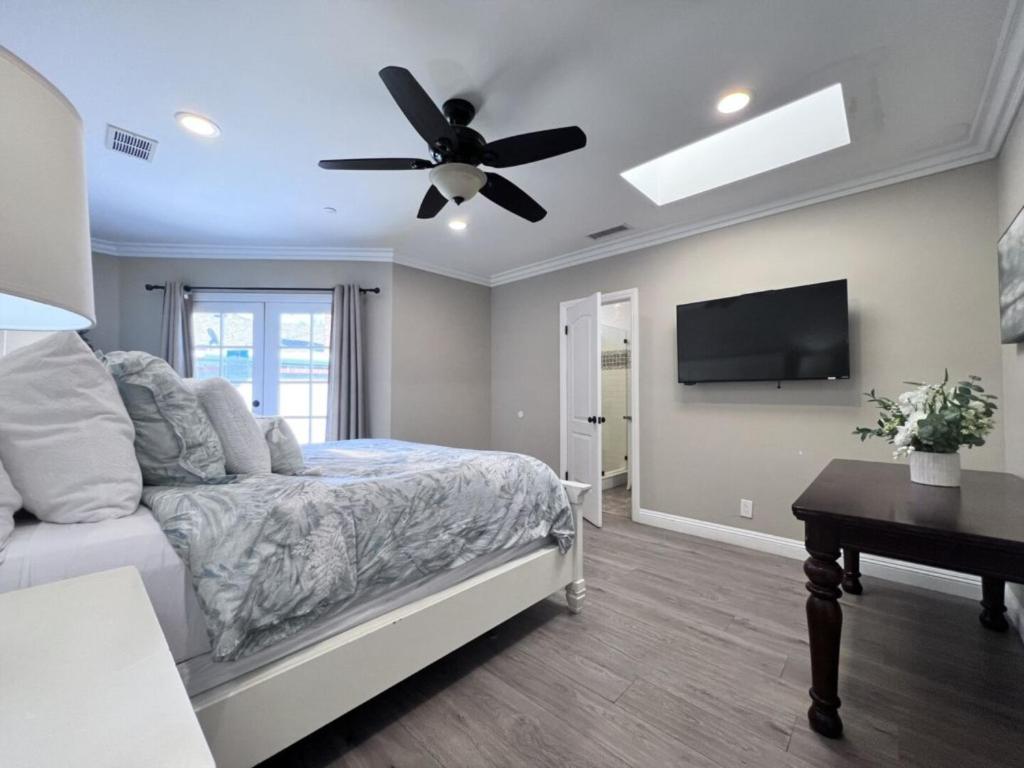 a bedroom with a bed and a ceiling fan at Stunning 8 bedroom 6 bathroom Pool Home in Anaheim