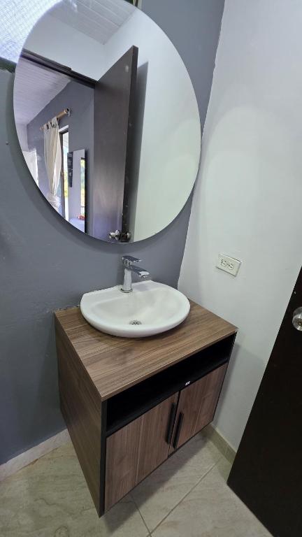 a bathroom with a sink and a mirror at CASA HOTEL COCORNa in Cocorná