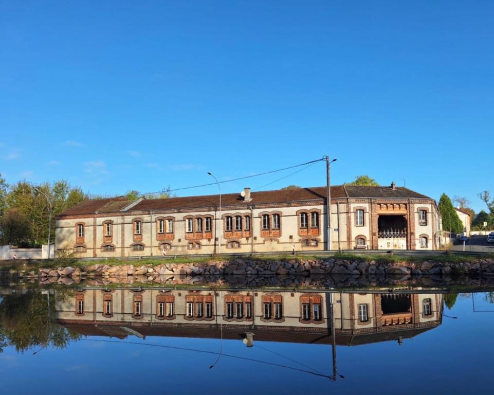 an old building with its reflection in the water at le relais Perrusson, Bed and breakfast et camping à la tuilerie in Écuisses