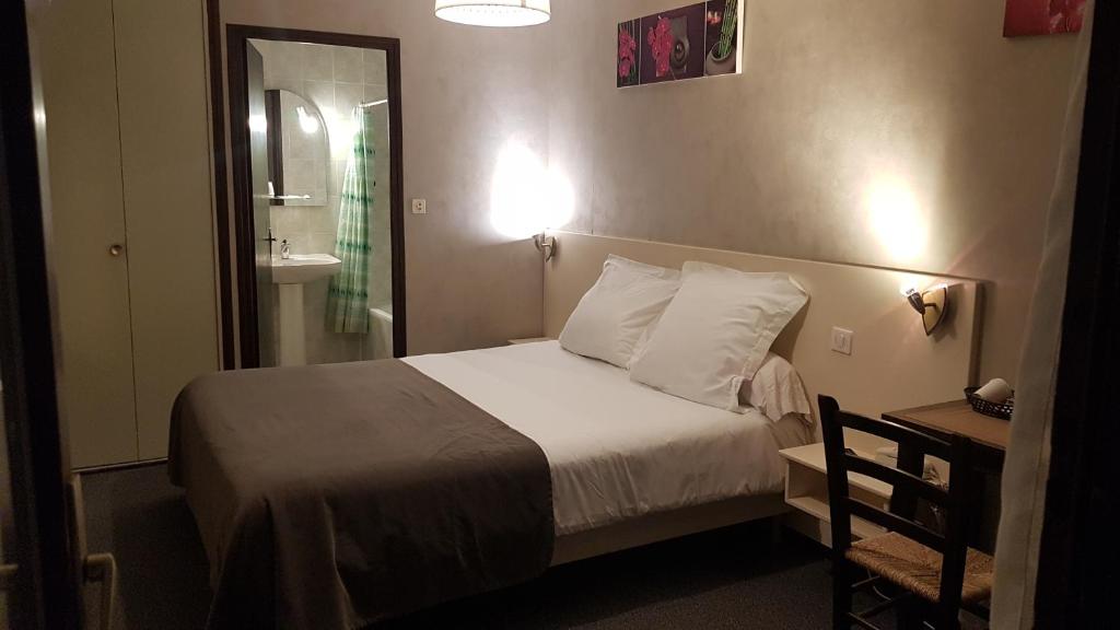 a hotel room with a bed and a bathroom at 24h sur24 in Foissac