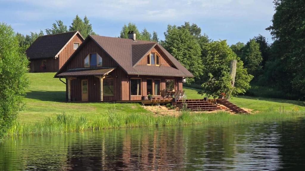 a house on a hill next to a body of water at Päikseranna Puhkemaja in Rõssa