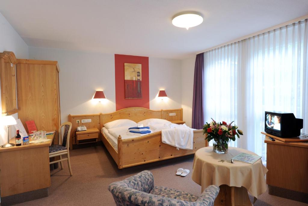 Habitación de hotel con cama, mesa y sillas en Landhotel Gasthof Krone, en Kupferzell