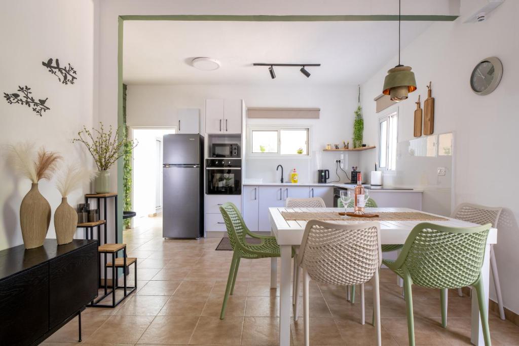 a kitchen with a table and chairs and a refrigerator at Villa 65 in Ilaniyya
