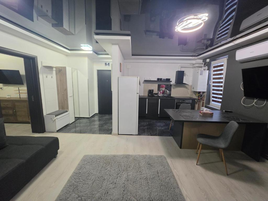 a living room with a desk and a kitchen at Apartament Eduard in Techirghiol