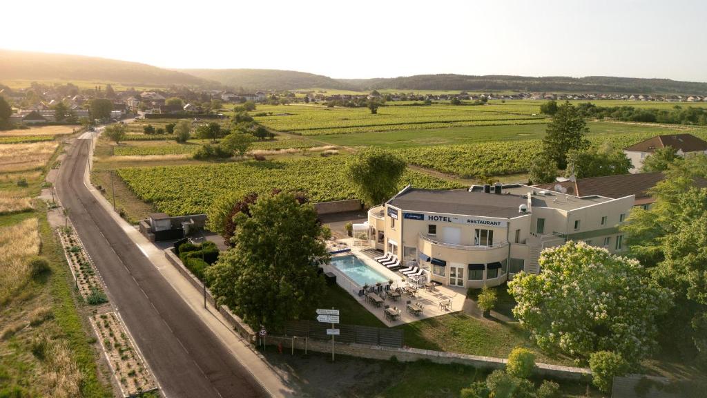 an aerial view of a large white house with a pool at TheOriginals City, Hôtel restaurant l'Ormichal Dijon Sud in Marsannay-la-Côte