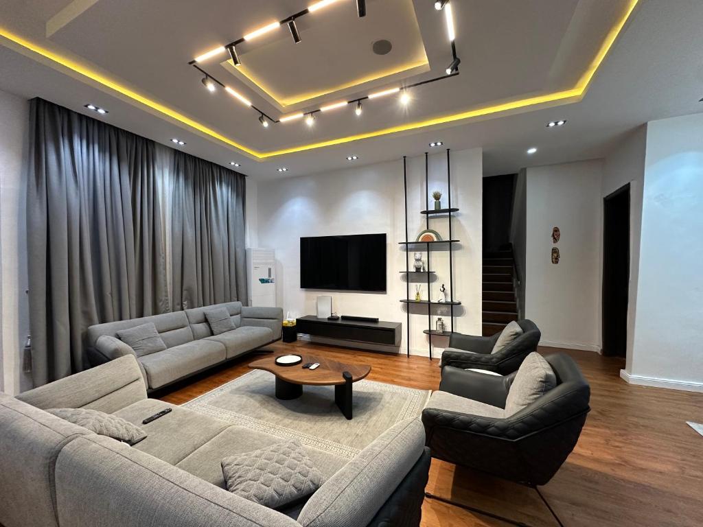 a living room with two couches and a tv at DOD Residence I Cozy 3BR with Fast Wifi in Ikuata