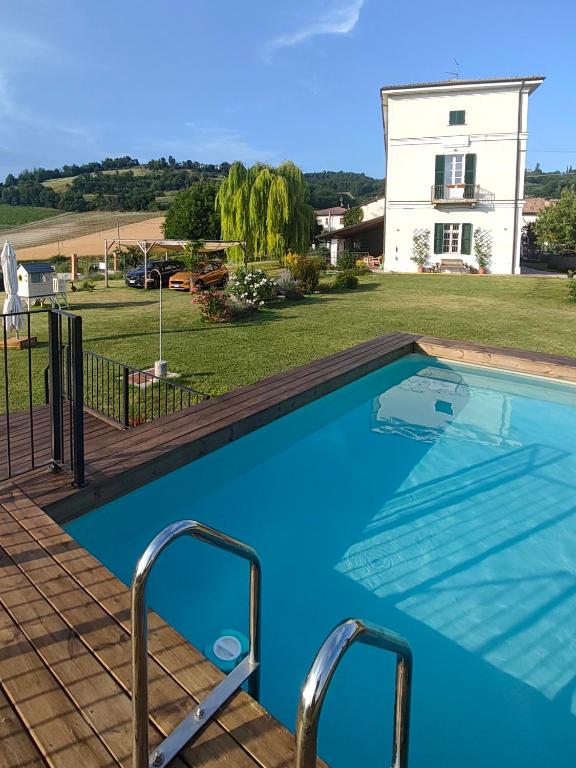a swimming pool with a house in the background at Subiet B&B in Moncalvo