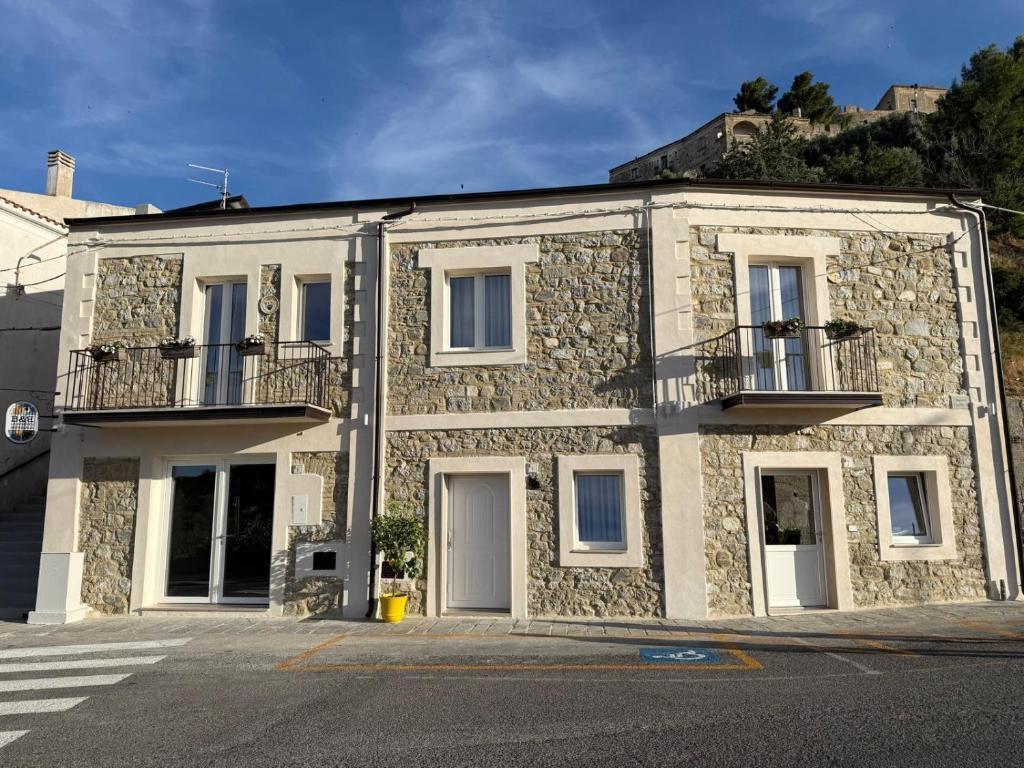 a stone building with a balcony on a street at La Dimora Imperiale in Rocca Imperiale
