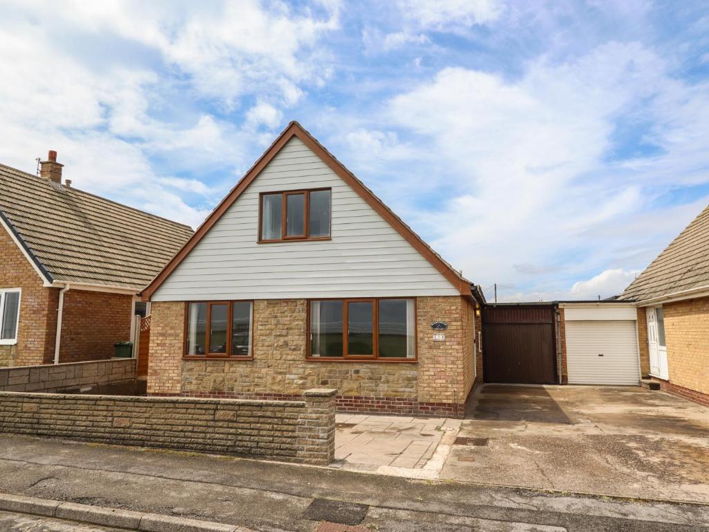a brick house with a garage at Sandringham in Withernsea