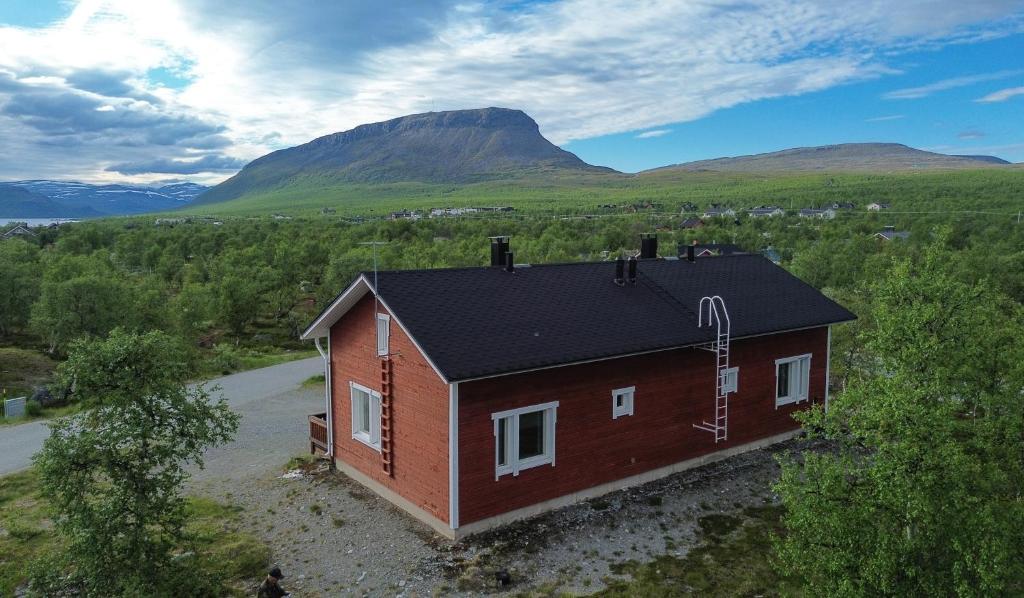 an aerial view of a house with mountains in the background at Ailakka, huoneisto A in Kilpisjärvi