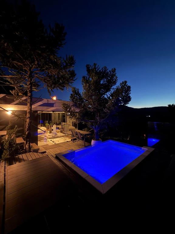 a blue swimming pool in a backyard at night at The Altitude Cabana 1373-Concrete in Mundo Novo