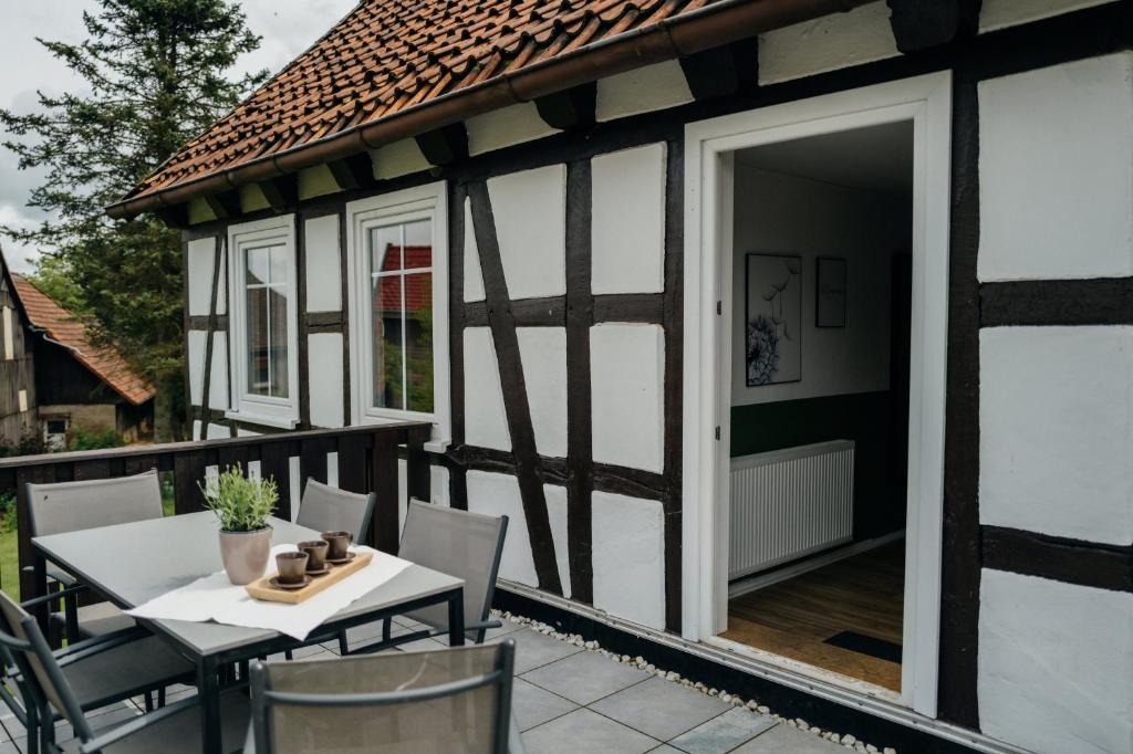 a patio with a table and chairs on a house at Hof Timmermann - Landhaus, oben in Ottenstein