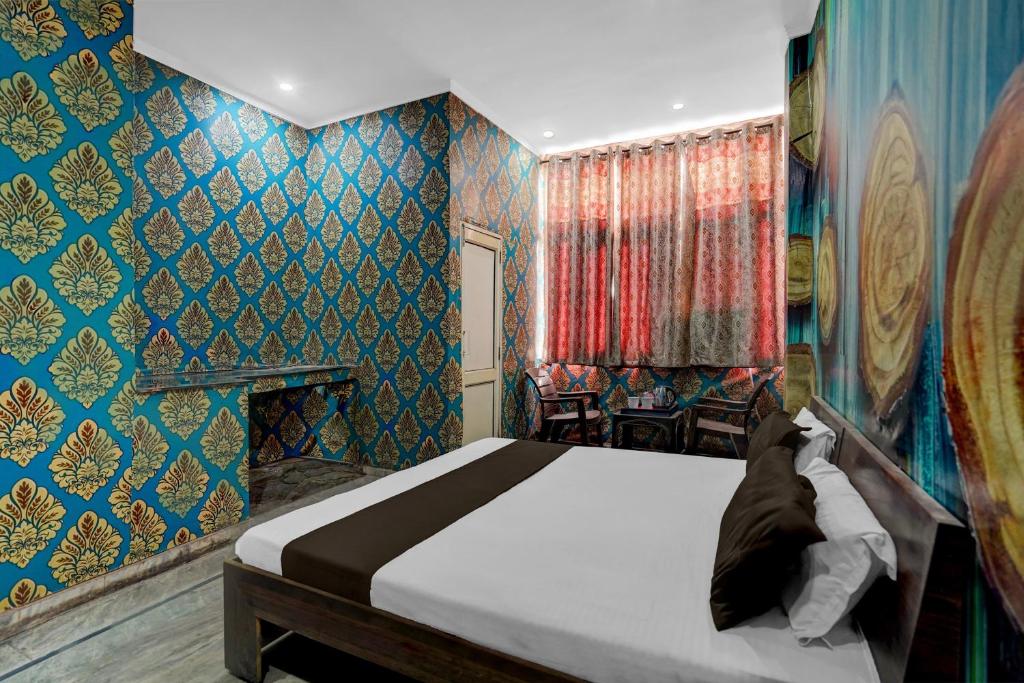 a bedroom with a bed and a blue wall at Hotel O Refinery Road Panipat Formerly Quinn in Pānīpat