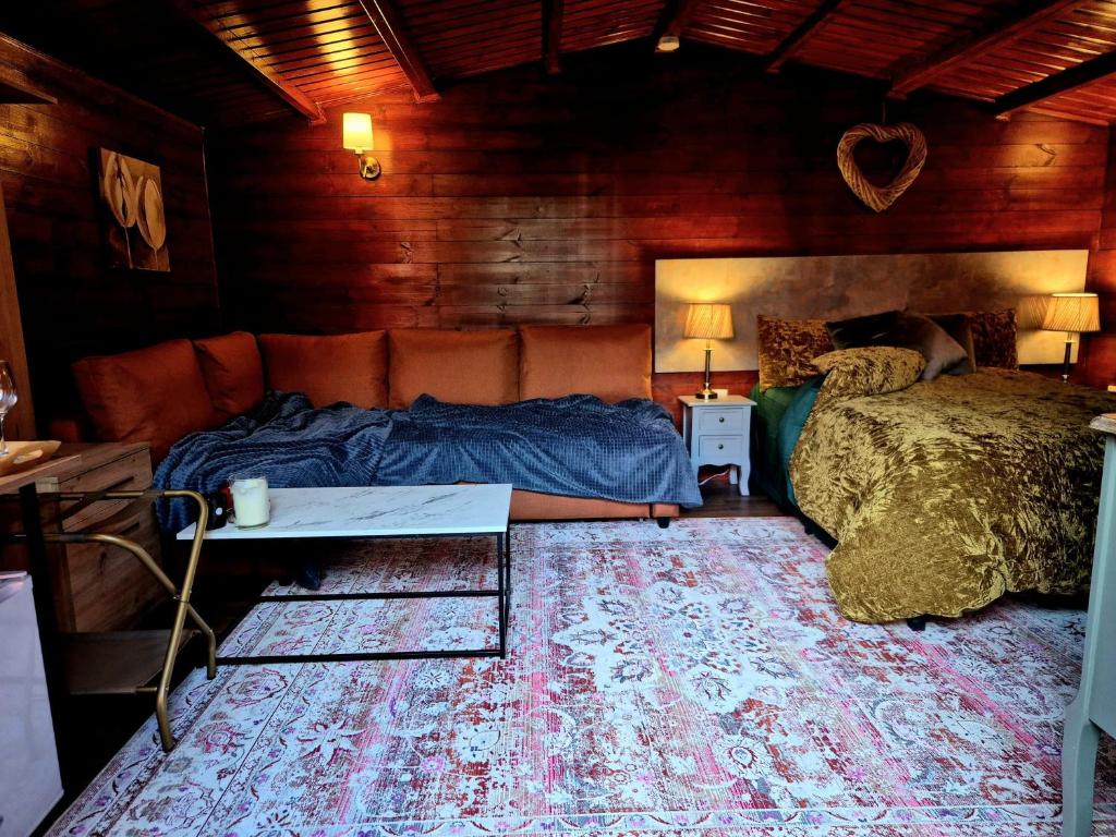 a bedroom with two beds and a table and a couch at Cabin39 in Barkingside