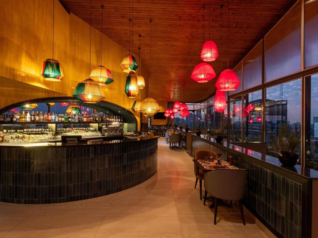 a restaurant with a bar with red lights at ibis Styles - Nairobi, Westlands in Nairobi