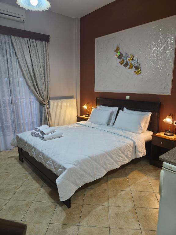 a bedroom with a large bed with white sheets at Xenonas Arxontiko in Kato Loutraki