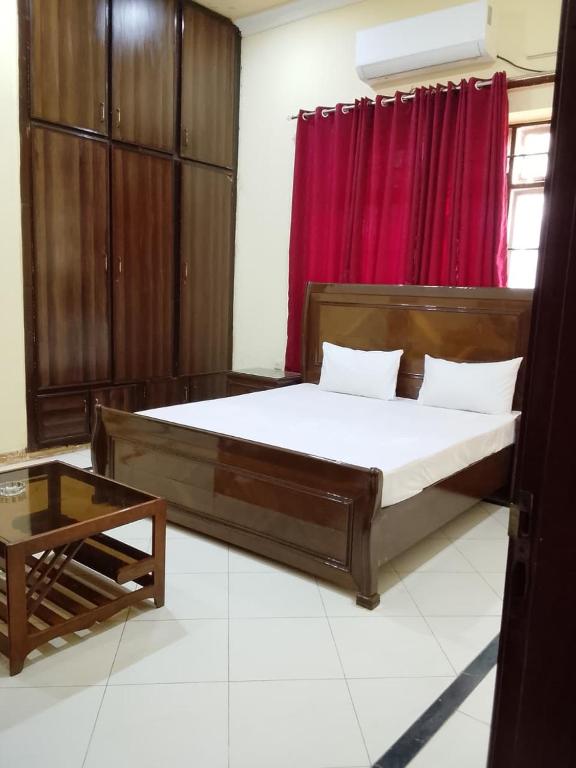 a bedroom with a large bed and a red curtain at Royal Heritage Lodges in Bahawalpur
