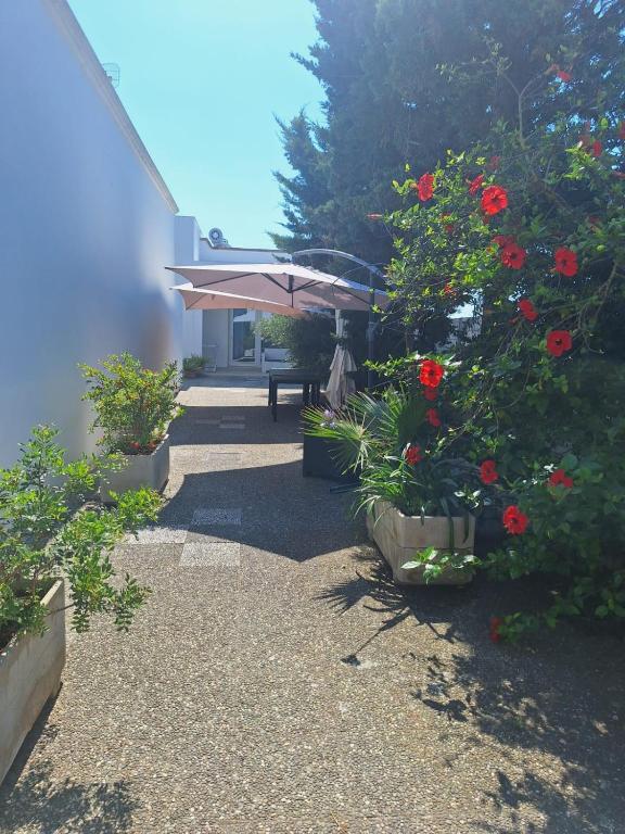 a patio with a bench and flowers and an umbrella at Da zia Sofia in Torre Lapillo