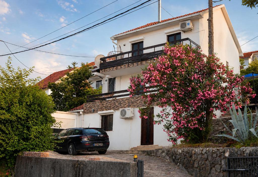 a white house with a car parked in front of it at Villa Bellevue Amazing Sea View 7 Guests in Krašići
