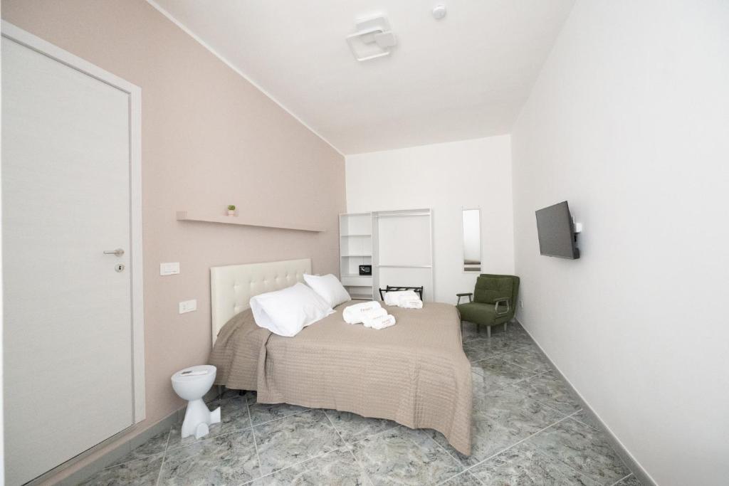 a white bedroom with a bed and a chair at B&B Francy and sons in Modugno