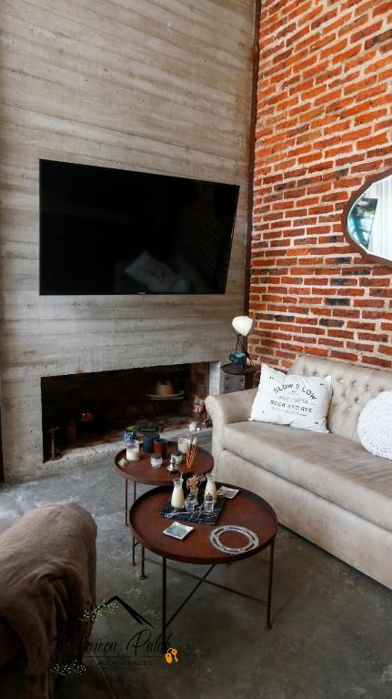 a living room with a couch and a brick wall at Loft Estilo Industrial in Ezeiza