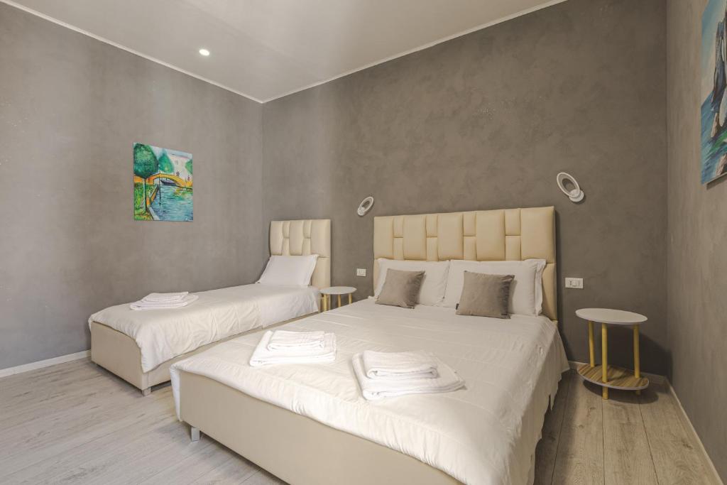 a bedroom with two beds with white sheets at Trieste Centro Rooms-camere eleganti in pieno centro in Trieste