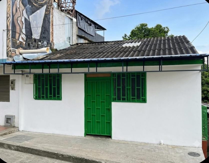 a white and green building with green doors at El Respiro in Buenavista