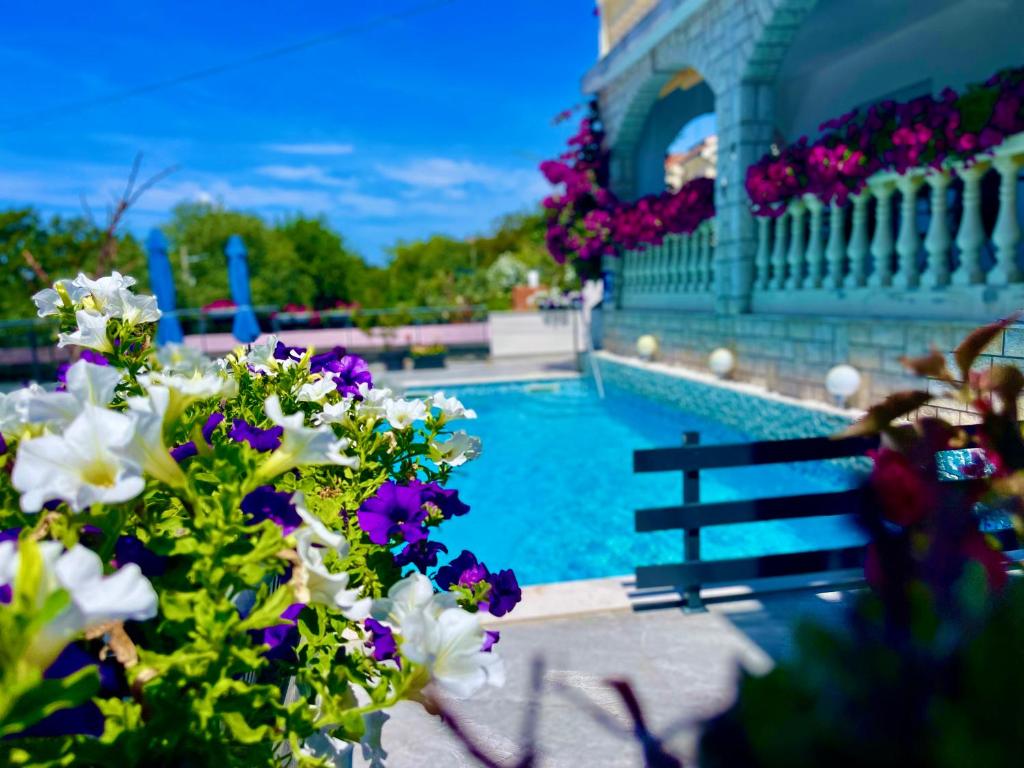 a swimming pool with flowers in front of a building at Marevista in Dramalj