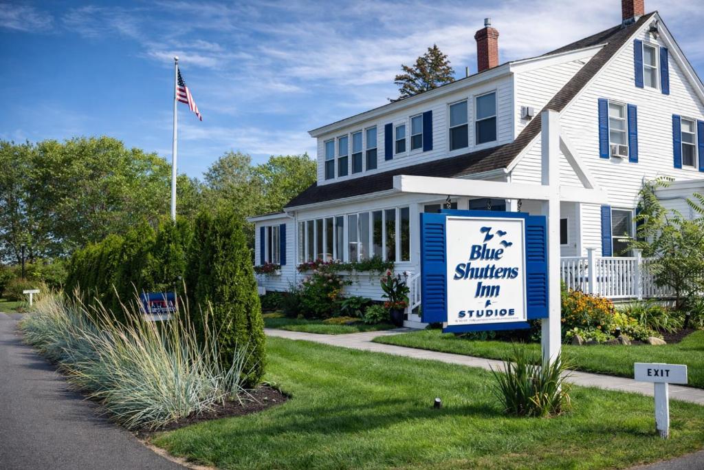 a white house with a blue shuttle sign in front of it at Blue Shutters Inn and Studios in Ogunquit