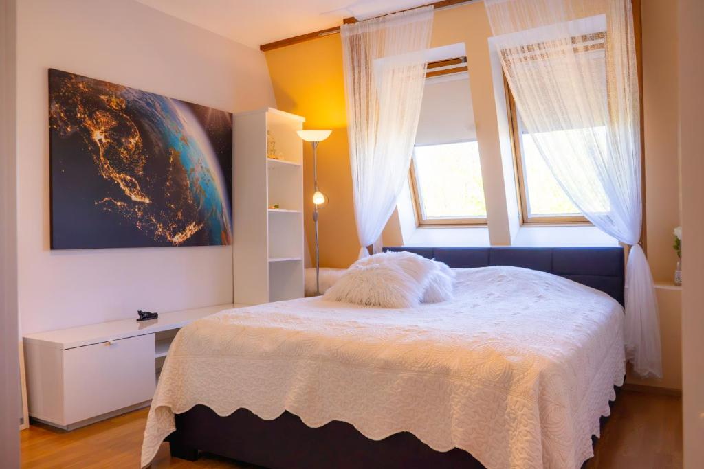 a bedroom with a bed and two windows at Bright Apartment in Haapsalu in Haapsalu