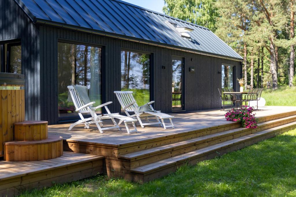 a deck with chairs and a table on a cabin at Kasispea Meremaja in Kasispea