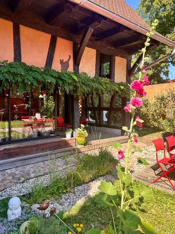 a garden with pink flowers in front of a house at B&B Le Lodge in Bourgheim
