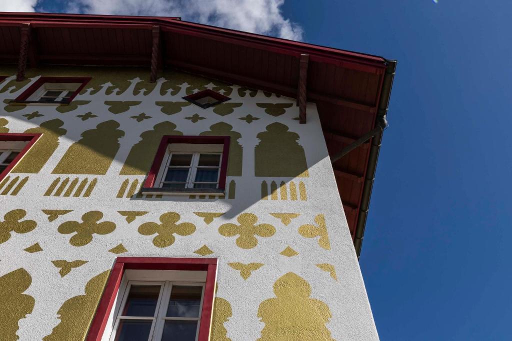 a building with flowers painted on the side of it at Hotel Pianta in Savognin