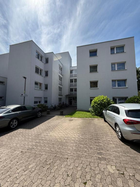 two cars parked in a parking lot in front of a building at Das kleine Zuhause 1 in Bad Driburg