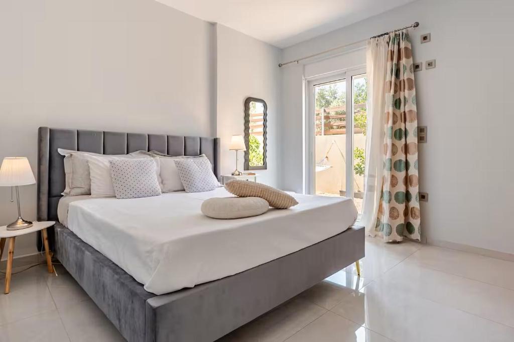 a bedroom with a large bed and a window at S&M Cozy Garden Lagonissi in Lagonissi