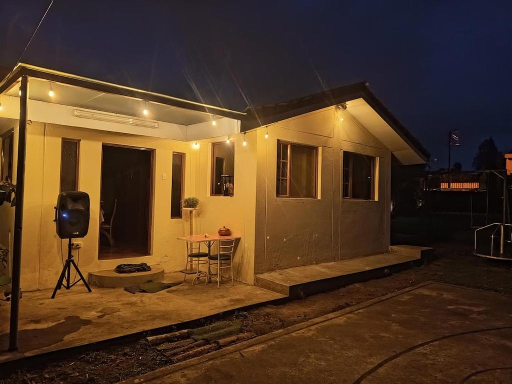 a small house with a table in front of it at night at Casa de campo san Andrés in Otavalo