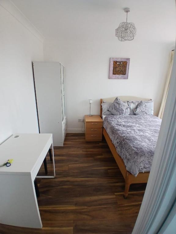 a bedroom with a bed and a white table at Connolly station homestay in Dublin