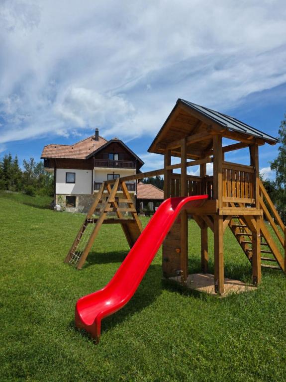 a playground with a red slide and a gazebo at Apartmani Suncani breg Tara in Mitrovac