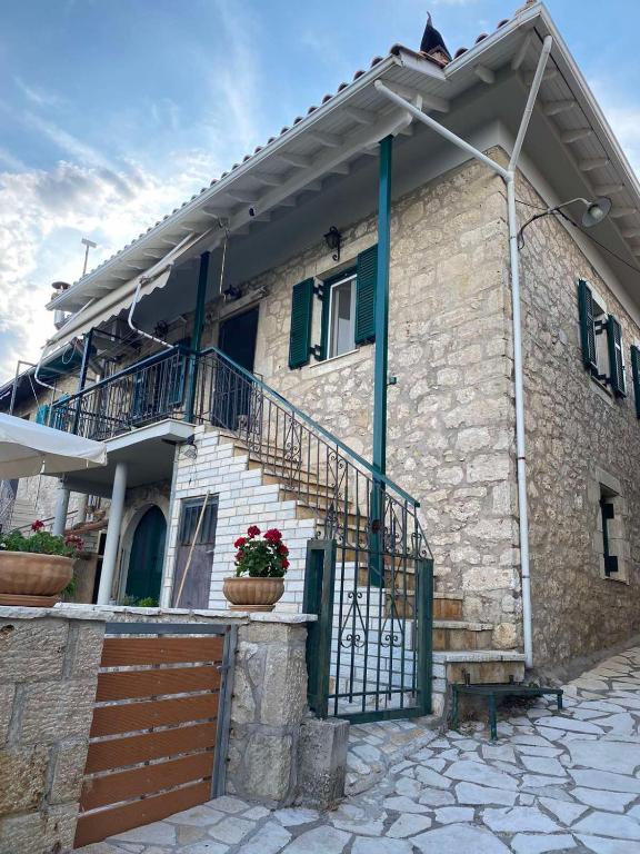 a stone house with a staircase and a balcony at Casa di TSANES in Pinakokhórion