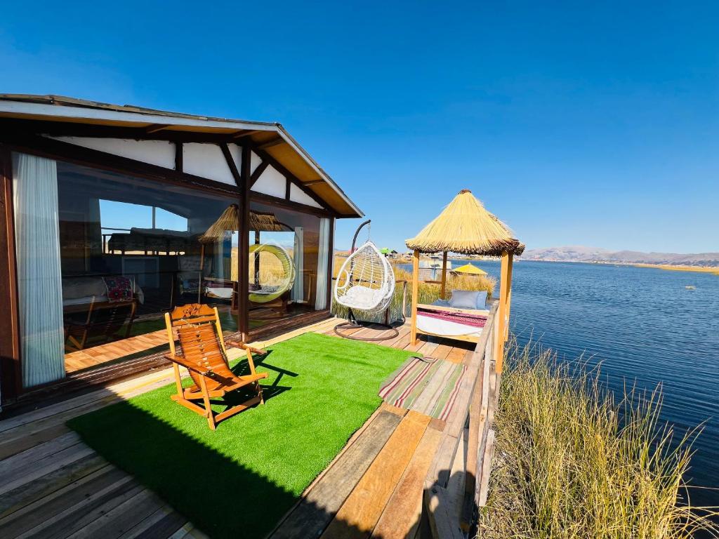 a deck with chairs and a gazebo on the water at Titikala in Puno