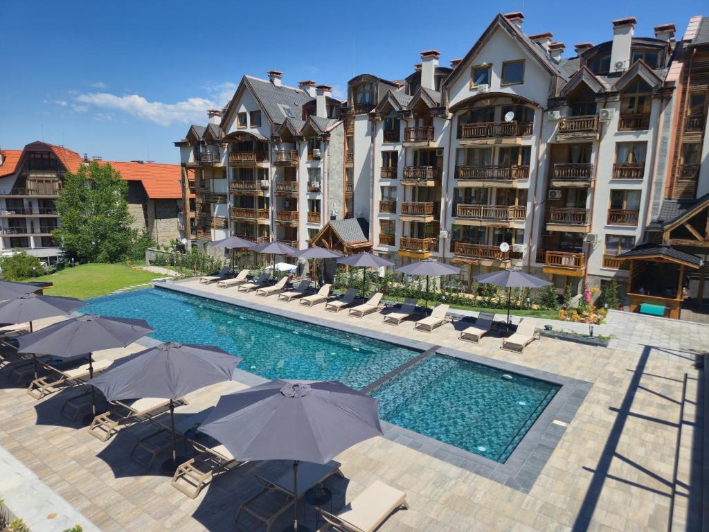 an aerial view of a hotel with a swimming pool with umbrellas at BOUTIQUE Hotel ENTRY E in Bansko