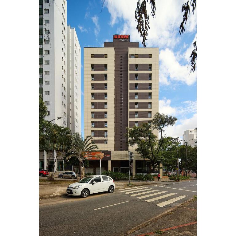 a white car parked in front of a building at Luggo Inter Residence - Região Central BH in Belo Horizonte