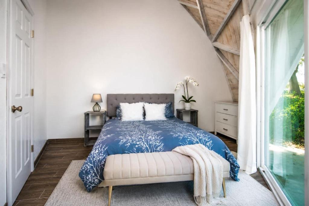a bedroom with a blue and white bed and a window at ROOM 03 - Lake Sumner in Clermont