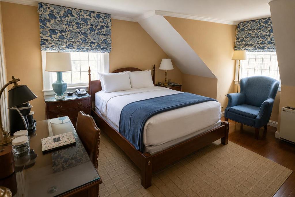 a bedroom with a bed and a desk and a chair at Inn on Boltwood in Amherst