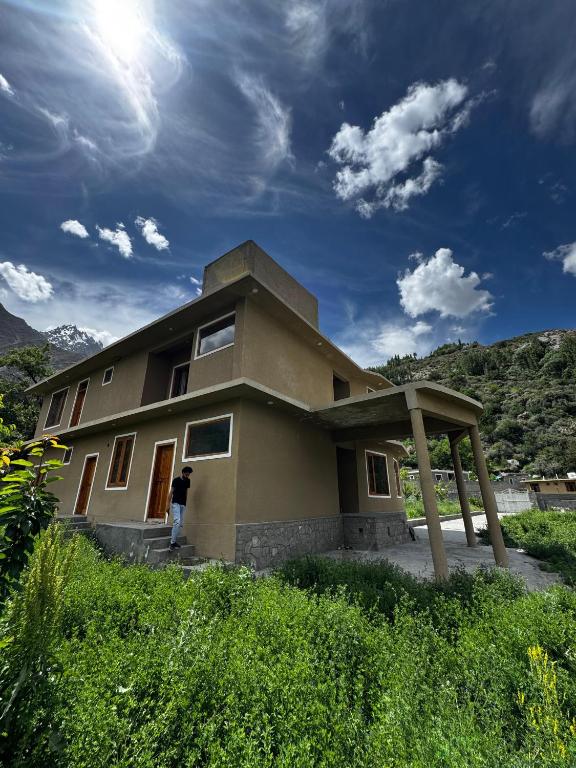 a person standing in front of a house at Marvoi resort in Hunza Valley