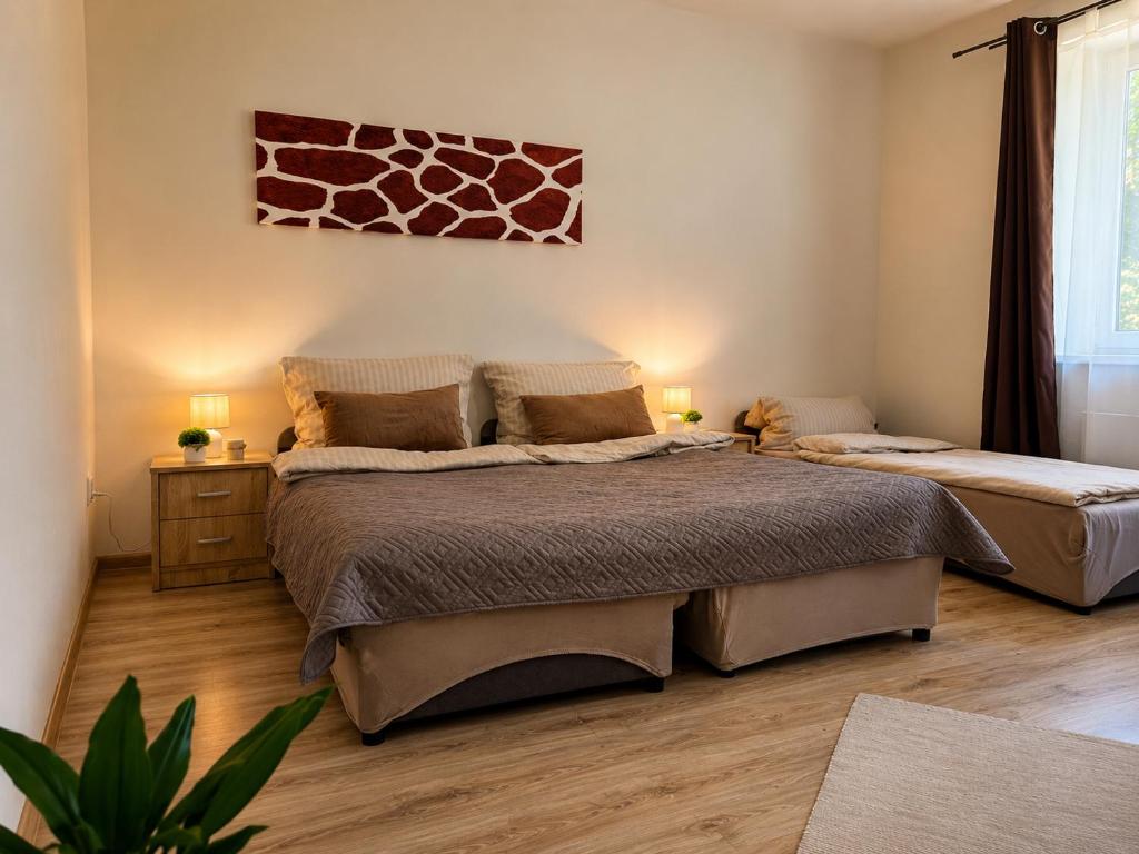 a bedroom with two beds and a painting on the wall at Lesný Dvor Retreat in Spišské Bystré